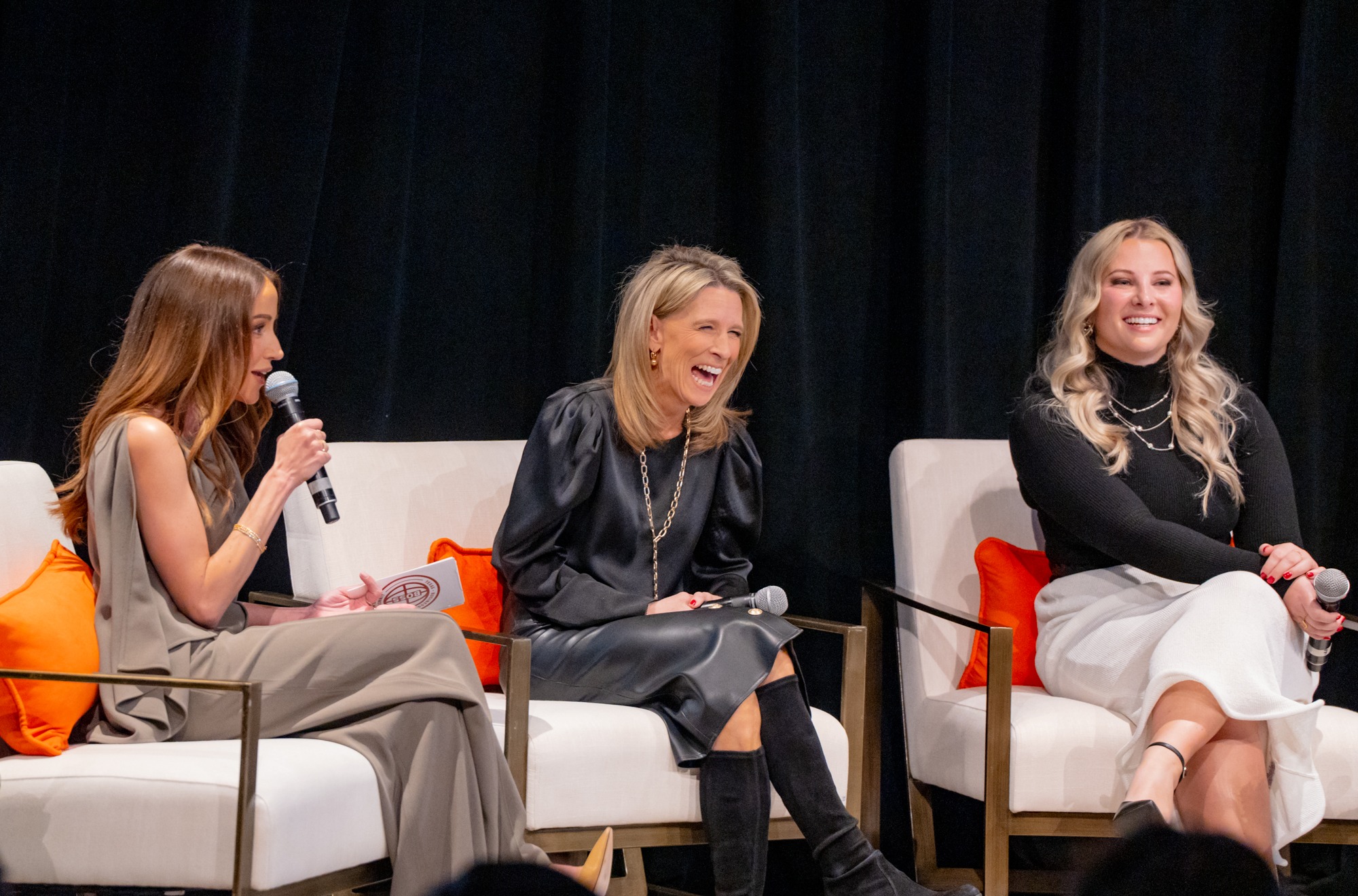Three speakers enjoying a lively conference panel discussion